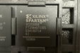 Xilinx Spartan FPGA chip with model number XC2S300E on a textured background
