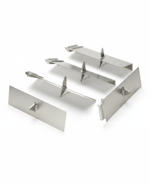 Three stainless steel mixing blades or agitator components arranged on a light gray surface.