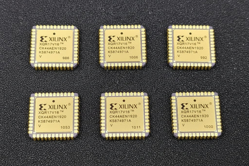 Five Xilinx chips on a dark surface